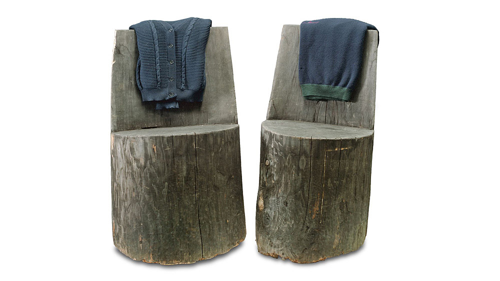 Zwei braune Stühle aus einem Holzstamm gearbeitet.