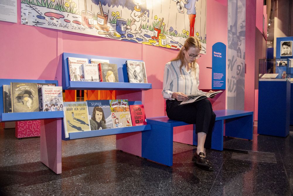 A visitor reads a book in the exhibition.