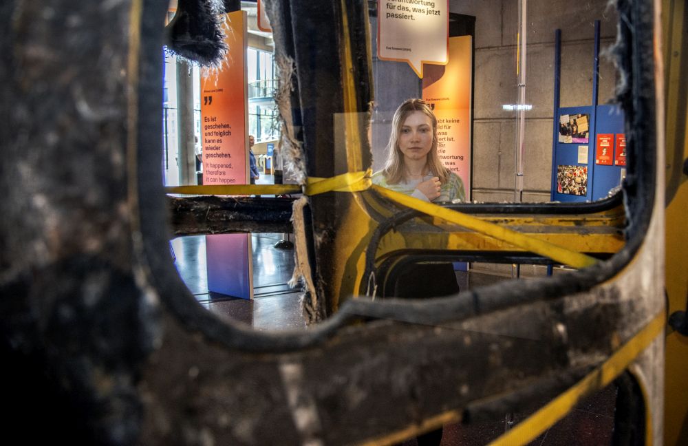 A visitor looks at a burnt-out book box