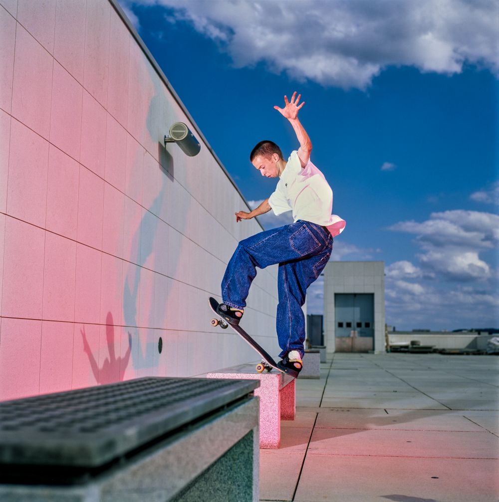 Ein Skater macht einen Trick auf dem Dach eines Gebäudes.