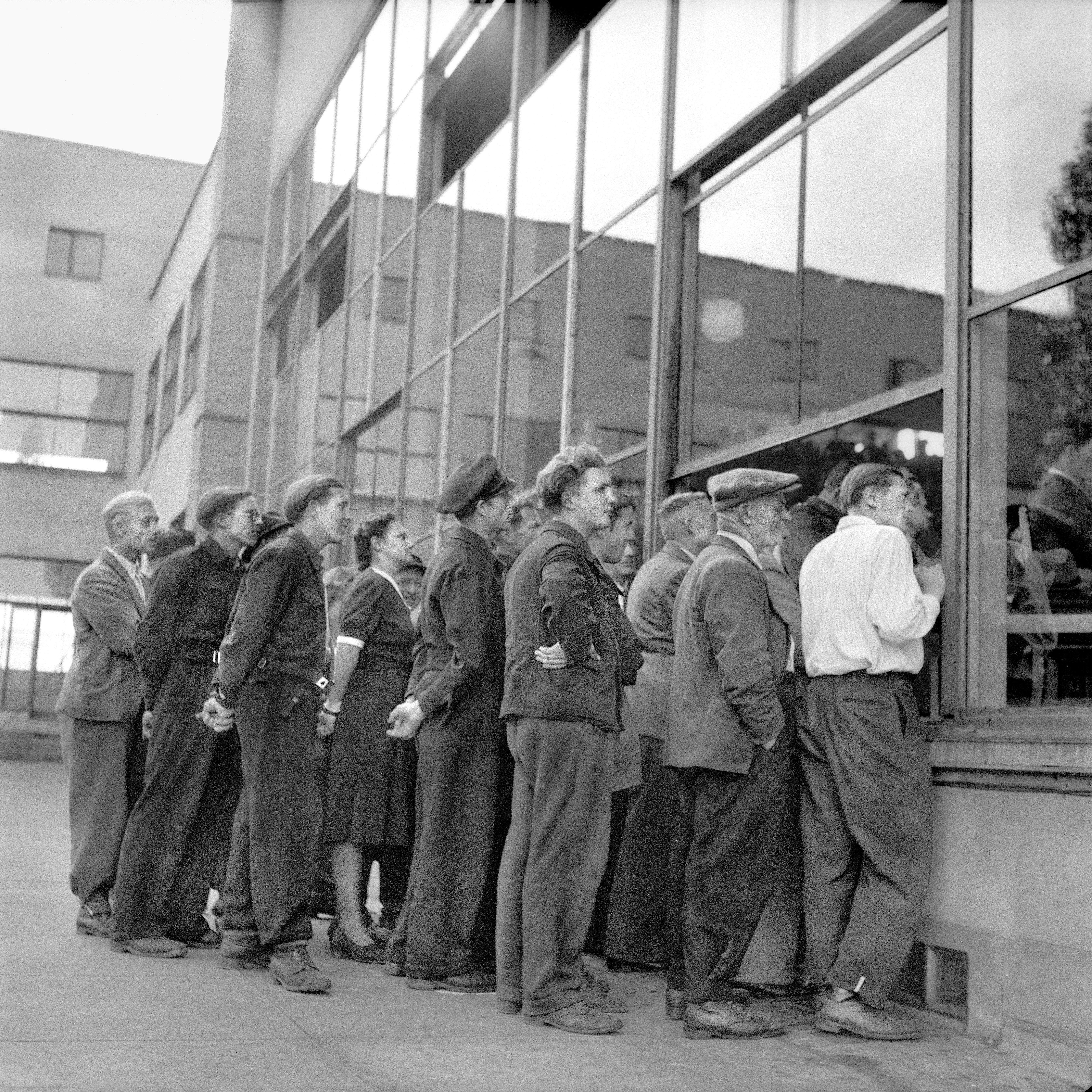 Durch die Glasfront und ein geöffnetes Fenster des Plenarsaals schaut eine Traube von Menschen ins Innere. 