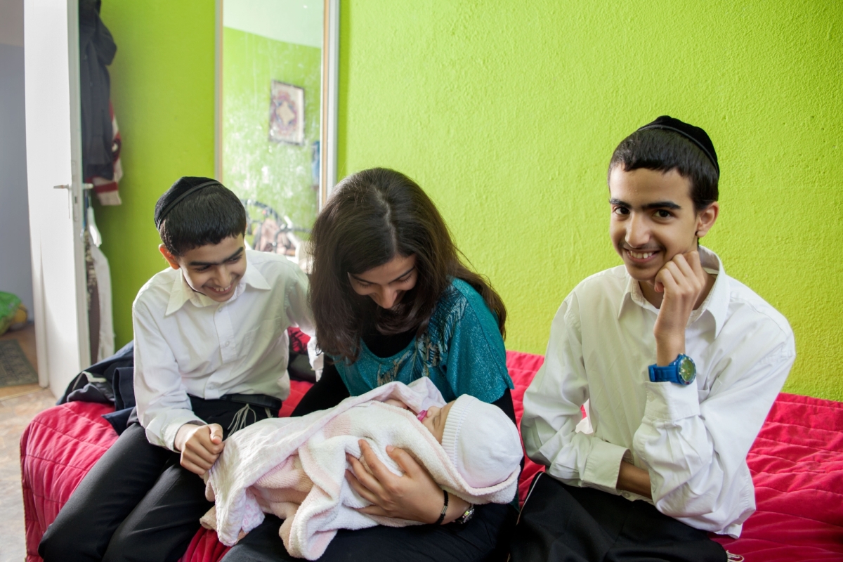 Photo of a Rabbi's family with their newborn child, by Benyamin Reich